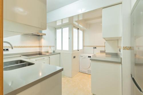 a large white kitchen with a sink and a dishwasher at Charming 3 Bedroom Apartment at Triana Center By Oui Seville in Seville