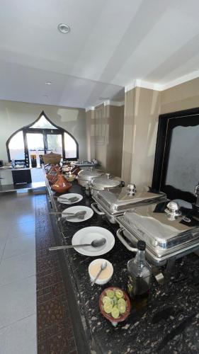 a buffet line with white plates in a restaurant at The Bedouin Moon in Dahab