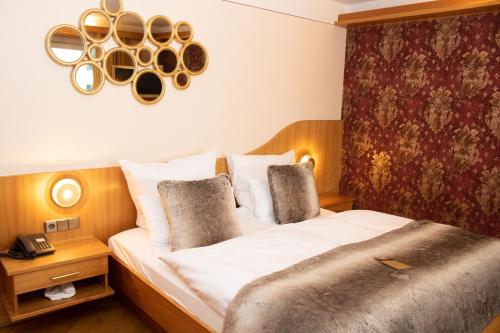 a hotel room with a bed and a clock on the wall at Boutiquehotel Liebesglück - adults only in Winterberg