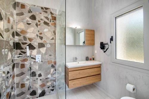a bathroom with a shower and a sink and a mirror at Tania Villa by PaxosRetreats in Gaios