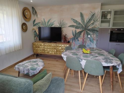 - un salon avec une table, des chaises et une télévision dans l'établissement Apartamento Dúplex Vistas al Valle de Incles Orenetes WiFi, à Soldeu