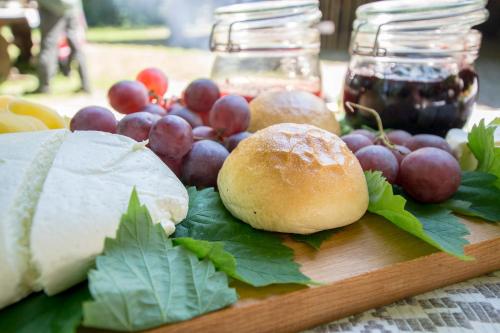 a cutting board with grapes and cheese on a table at Pensjonat Uroczysko Zaborek in Janów Podlaski