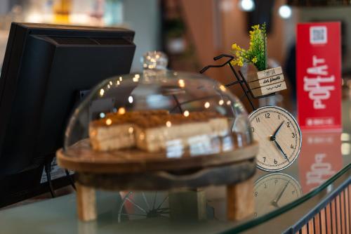 a glass table with a clock and a table with a clock and a table sidx at Ibis Madrid Alcobendas in Alcobendas