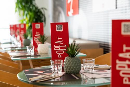 a table in a restaurant with red signs and glasses at Ibis Madrid Alcobendas in Alcobendas