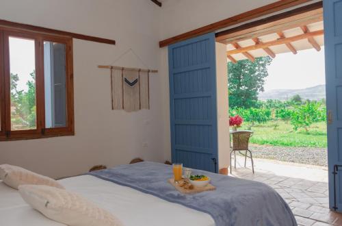 a bedroom with a blue door and a table with food on it at Trinitarios in Barichara