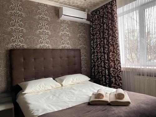 a bedroom with a bed with two towels on it at Nirvana in Rivne