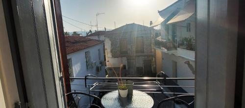balcone con tavolo e vista sulla città di Coco Luxury Apartments a Poros
