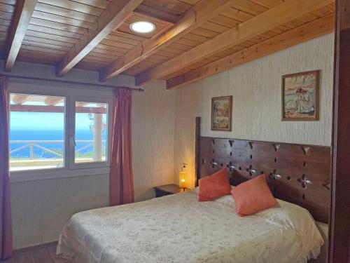 a bedroom with a bed with a view of the ocean at TENERIFE ECOLIFE HOUSES by APARTAMENTOS ESTRELLA DEL NORTE in Garachico