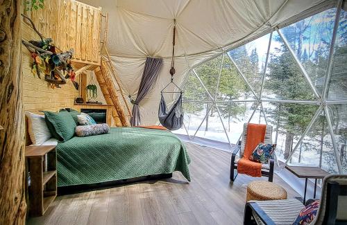 een slaapkamer met een bed in een tent bij Quisibis Dômes in Riviere-Verte