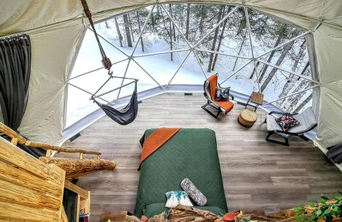 a room with a tent with a hammock in it at Quisibis Dômes in Riviere-Verte