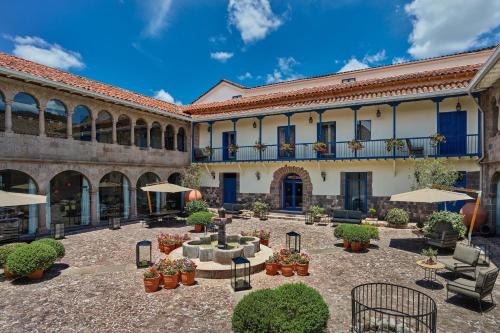 einen Innenhof in einem Gebäude mit Tischen und Sonnenschirmen in der Unterkunft Palacio del Inka, a Luxury Collection Hotel, Cusco in Cusco