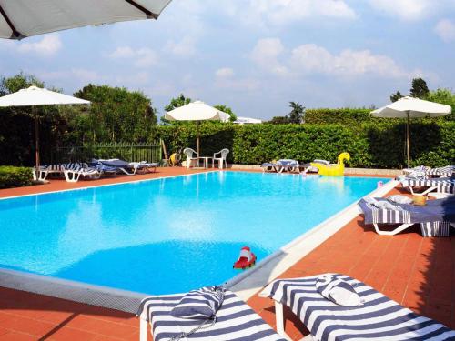 a swimming pool with lounge chairs and umbrellas at BellaSirmione Holiday Apartments in Sirmione