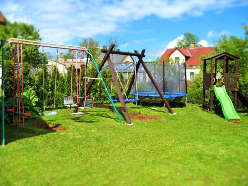 a playground with a bunch of swings in a yard at Jūra in Ventspils