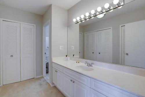 a white bathroom with a sink and a mirror at Amazing 2 BR Apt + Den @Crystal City With Gym in Arlington