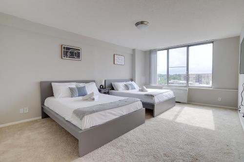 1 dormitorio con 2 camas y ventana grande en Amazing 2 BR Apt + Den @Crystal City With Gym en Arlington