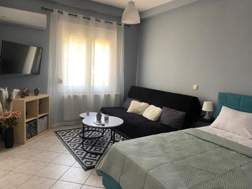 uma sala de estar com uma cama e um sofá em Maria's Apartment! em Igoumenitsa