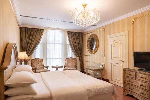 a bedroom with a large bed and a chandelier at Le Meridien Medina in Al Madinah