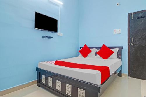 - une chambre avec un lit et une télévision murale dans l'établissement OYO Flagship Hanuma Residencies, à Hyderabad