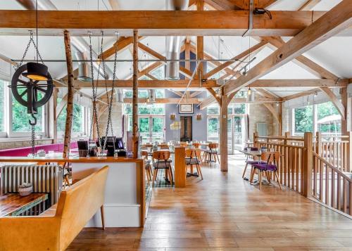 un restaurante con techos de madera, mesas y sillas en Bath Mill Lodge Retreat, en Bath
