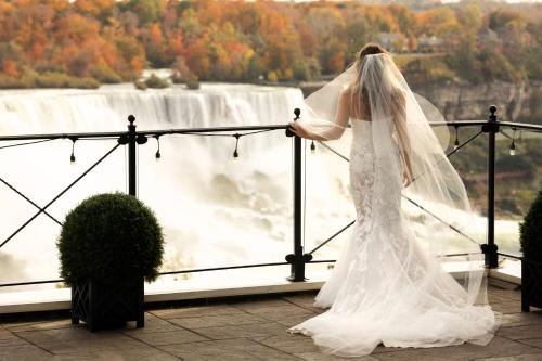 a woman in a wedding dress looking at a waterfall at Sheraton Fallsview Hotel in Niagara Falls