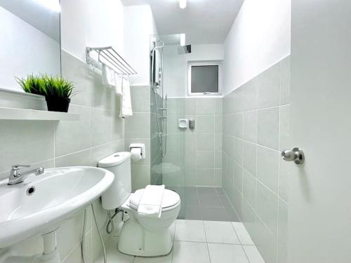 a white bathroom with a toilet and a sink at 3BR Modern Cozy Suite Near KLIA in Sepang