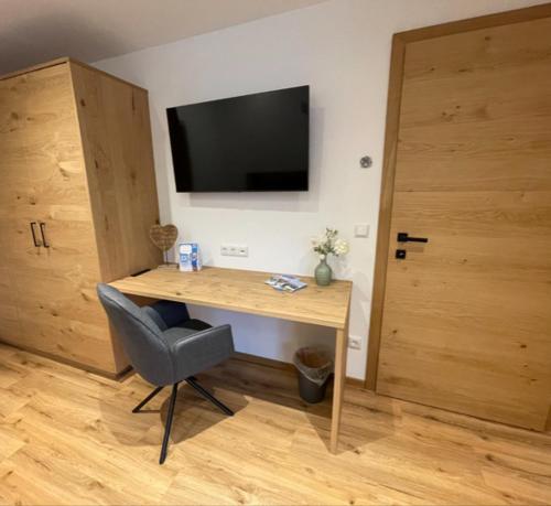 a room with a desk with a television and a chair at Alpenglück - Hinterthal in Hinterthal