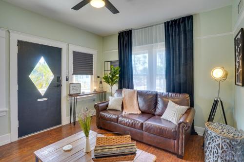 a living room with a brown leather couch and a table at 1 Mi to Dtwn! Bright Long Beach Apartment in Long Beach