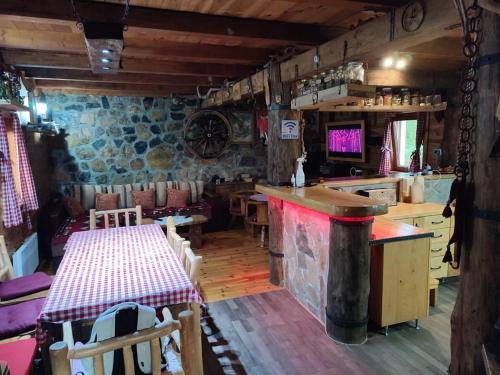 a restaurant with a table and a bar in a room at Vikendica MILA in Kolašin