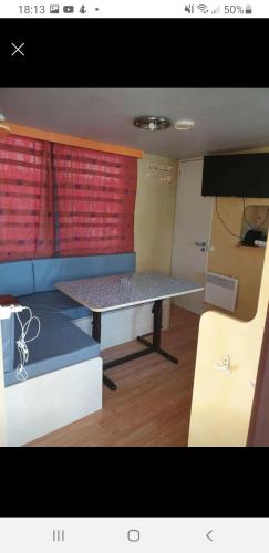 a small room with a table and a couch at Mobile home dans camping frejus in Fréjus
