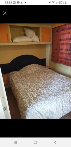 a bedroom with a bed and shelves in it at Mobile home dans camping frejus in Fréjus