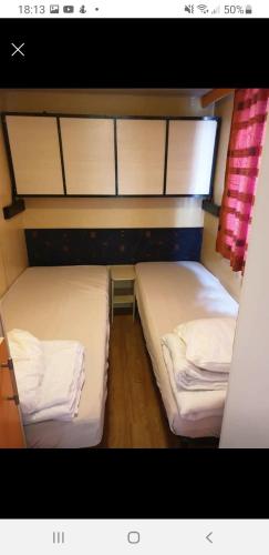 2 łóżka pojedyncze w małym pokoju z: w obiekcie Mobile home dans camping frejus w Fréjus