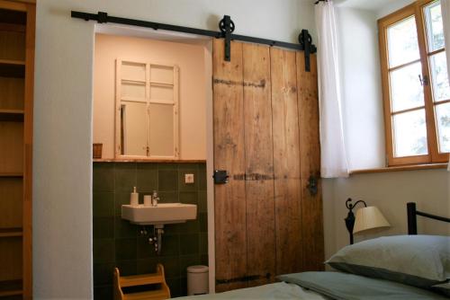 a bathroom with a sink and a wooden door at Schlossmühle Schieritz in der Nähe von Meißen in Schieritz