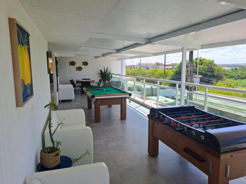 a living room with a pool table on a balcony at Vivenda dos Corais in Porto De Galinhas