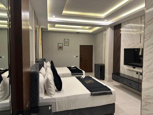 um quarto de hotel com uma cama e uma televisão em The Signature Hotel em Islamabad