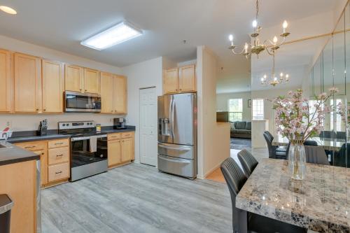 a kitchen with wooden cabinets and a table with a vase of flowers at Owings Mills Townhouse 8 Mi to Liberty Reservoir! in Owings Mills