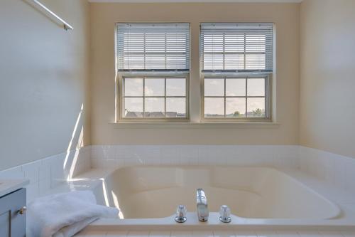 een wit bad met een wastafel en 2 ramen bij Owings Mills Townhouse 8 Mi to Liberty Reservoir! in Owings Mills