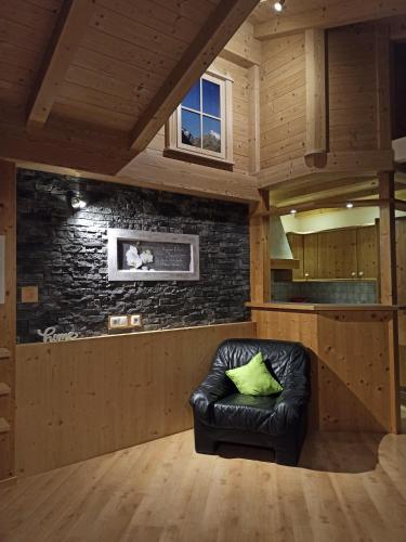 ein schwarzes Ledersofa in einem Zimmer mit Ziegelwand in der Unterkunft Conny's Ferienwohnungen in Gschnitz
