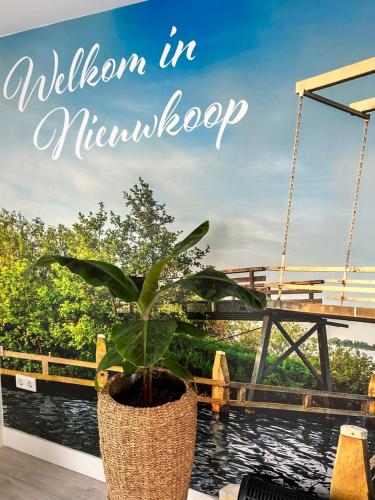a plant in a pot in front of a bridge at Casa aan de Plas, B&B met sauna en hottub of jacuzzi in Nieuwkoop