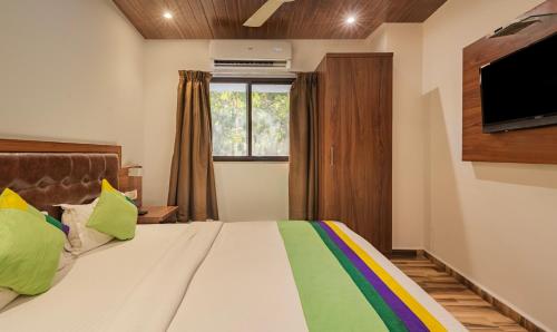 a bedroom with a large bed with a tv on the wall at Treebo Seven Olives in Mumbai