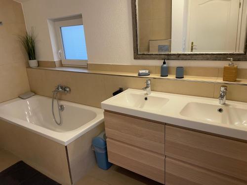 a bathroom with two sinks and a tub and a mirror at Familien Ferienhaus in Memmingen 3 Zimmer mit 2 Bädern in Memmingen