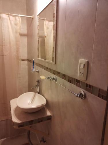 a bathroom with a sink and a shower with a mirror at Casa de Jose in Santiago del Estero