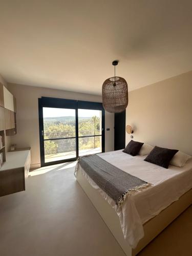 une chambre avec un grand lit et une grande fenêtre dans l'établissement Belle maison contemporaine, à Ampus