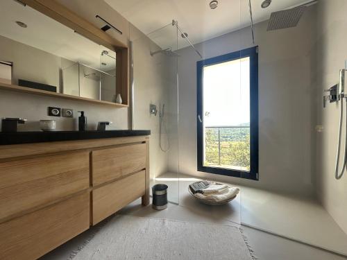 une salle de bain avec un lavabo et une fenêtre dans l'établissement Belle maison contemporaine, à Ampus
