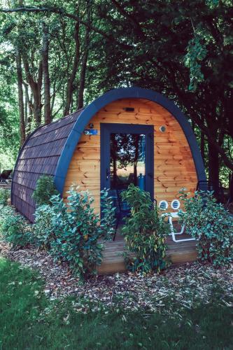 a small shed with a door in the grass at Hôtel Les Jardins de Deauville in Saint-Martin-aux-Chartrains
