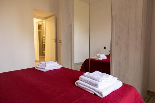 a room with a red bed with towels on it at Domus Re Ferdinando - AIRPORT in Naples