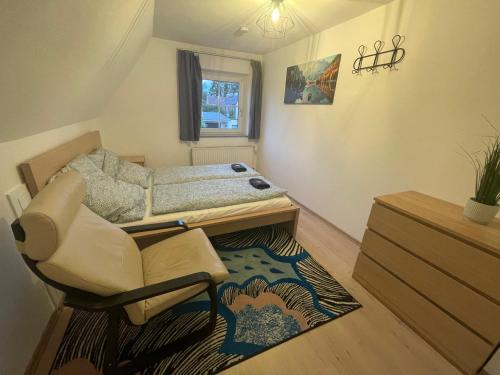 a small room with a bed and a chair at Familien Ferienhaus in Memmingen 3 Zimmer mit 2 Bädern in Memmingen