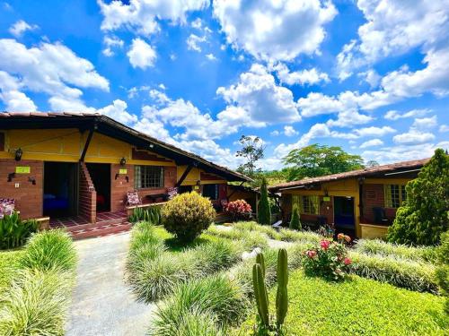 a garden in front of a house with plants at Hotel Campestre La Primavera del Quindío in Montenegro