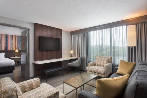 a hotel room with a bed and a living room at Nashville Marriott at Vanderbilt University in Nashville