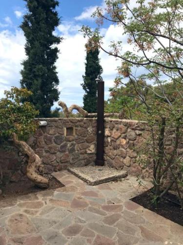 a stone wall with a black pole on it at new serenity villa aegina in Aegina Town