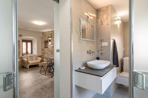 une salle de bain avec un lavabo et des toilettes dans une chambre dans l'établissement Apartman Stefani, à Krk